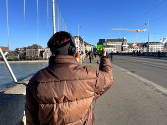 Jeannie wie sie auf der Mittleren Brücke in Basel die Folge «Mittlere Brücke» hört.